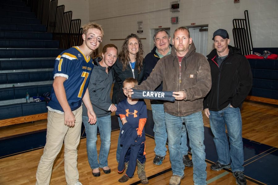 Grand Ledge Senior linebacker, Bear Nelson, taking a photo with the family of one of our fallen heroes.