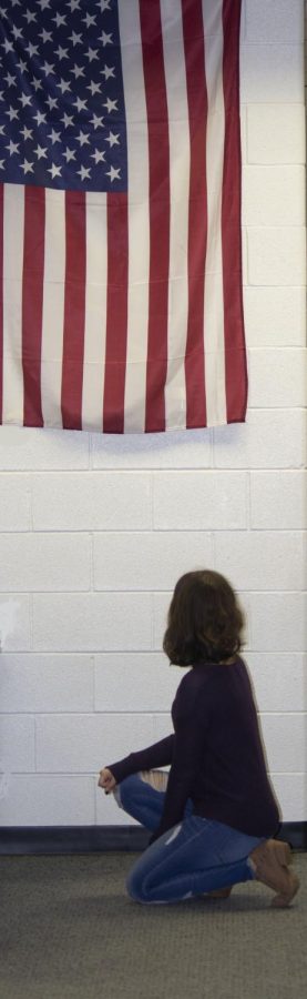 Author+Hannah+Rose+kneels+in+front+of+an+American+flag.+She+does+so+in+support+of+Kaepernick%27s+protest%2C+not+to+disrespect+the+flag+or+the+Soldiers+that+fight+for+the+freedom+it+represents.+