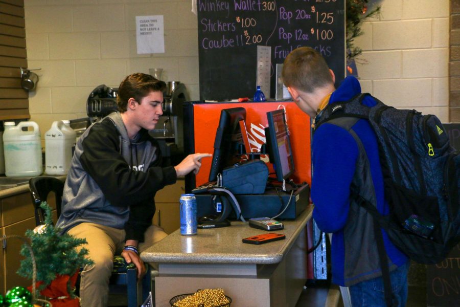 Senior Payton Wieber sells a drink from the Comet Connection to freshman William Leisenring. Wieber was doing so as a student in Mr. Millers Marketing class.