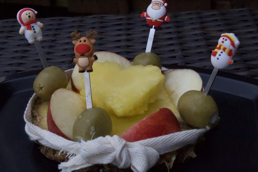 A plate with different types of fruit like pineapples, apples and olives. This fruit plate was made as a healthy alternative snack.
