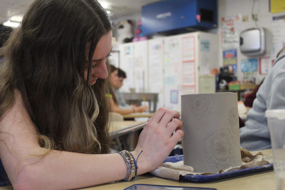 Layna+Norick+carves+intricate+details+into+her+ceramics+project.+After+Vandyke-Moore+retired%2C+Thompson+took+over+instructing+the+course+for+the+remainder+of+the+2023-2024+school+year.