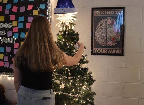 Mrs. Hengesbach has students decorate her classroom Christmas tree with lights and bulbs. The students had a great time with helping her commemorate the holidays.