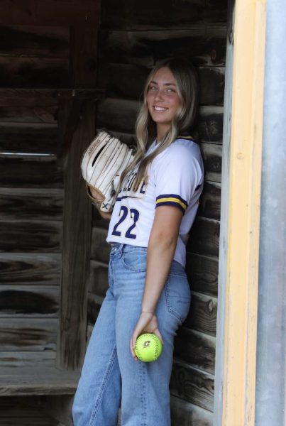 Jade poses for the camera showing CMU pride with her jersey and softball. Queen will proudly represent the Chippewas next fall.