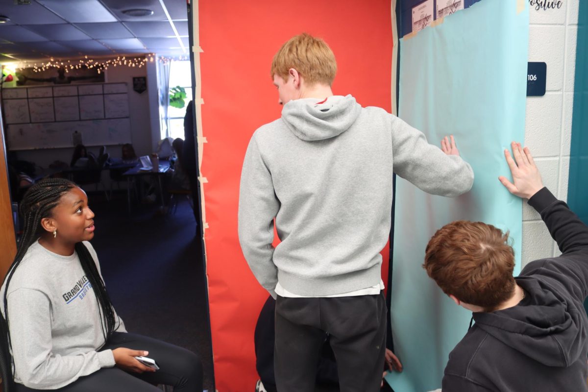 Students decorate classroom doors for the annual door-decorating contest. This year, students in Mr. Heany’s class designed an elf-themed door; this photo shows the beginning of that process.