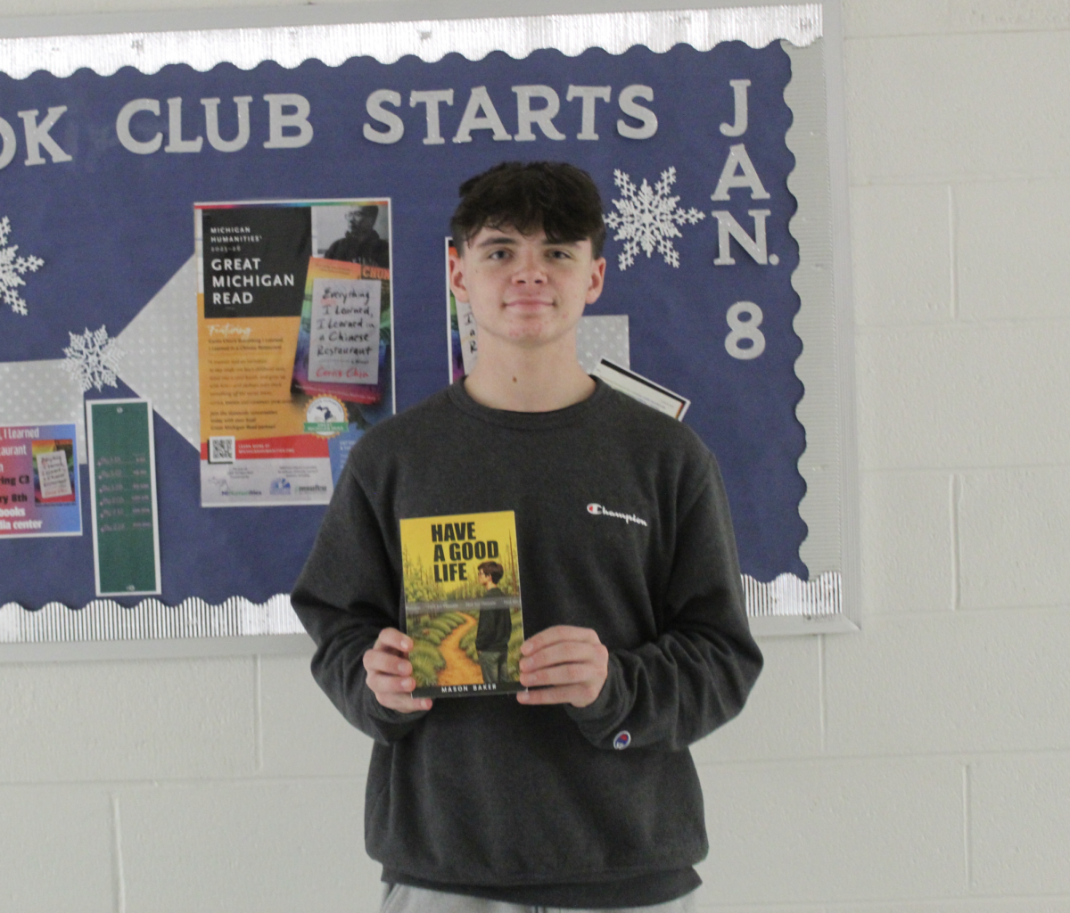 Mason Baker holds up his very first published book. He plans on writing more in the future.