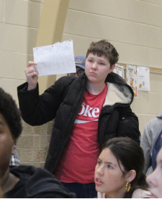 Student holds up a homemade sign on the
sidelines of the protest. There were six speeches just a few feet away.