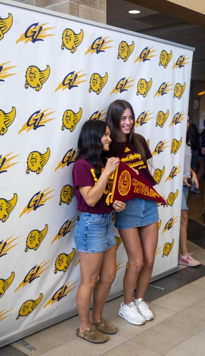 Taylor Pung and Cecilia Mance pose for a photo with their decided school.